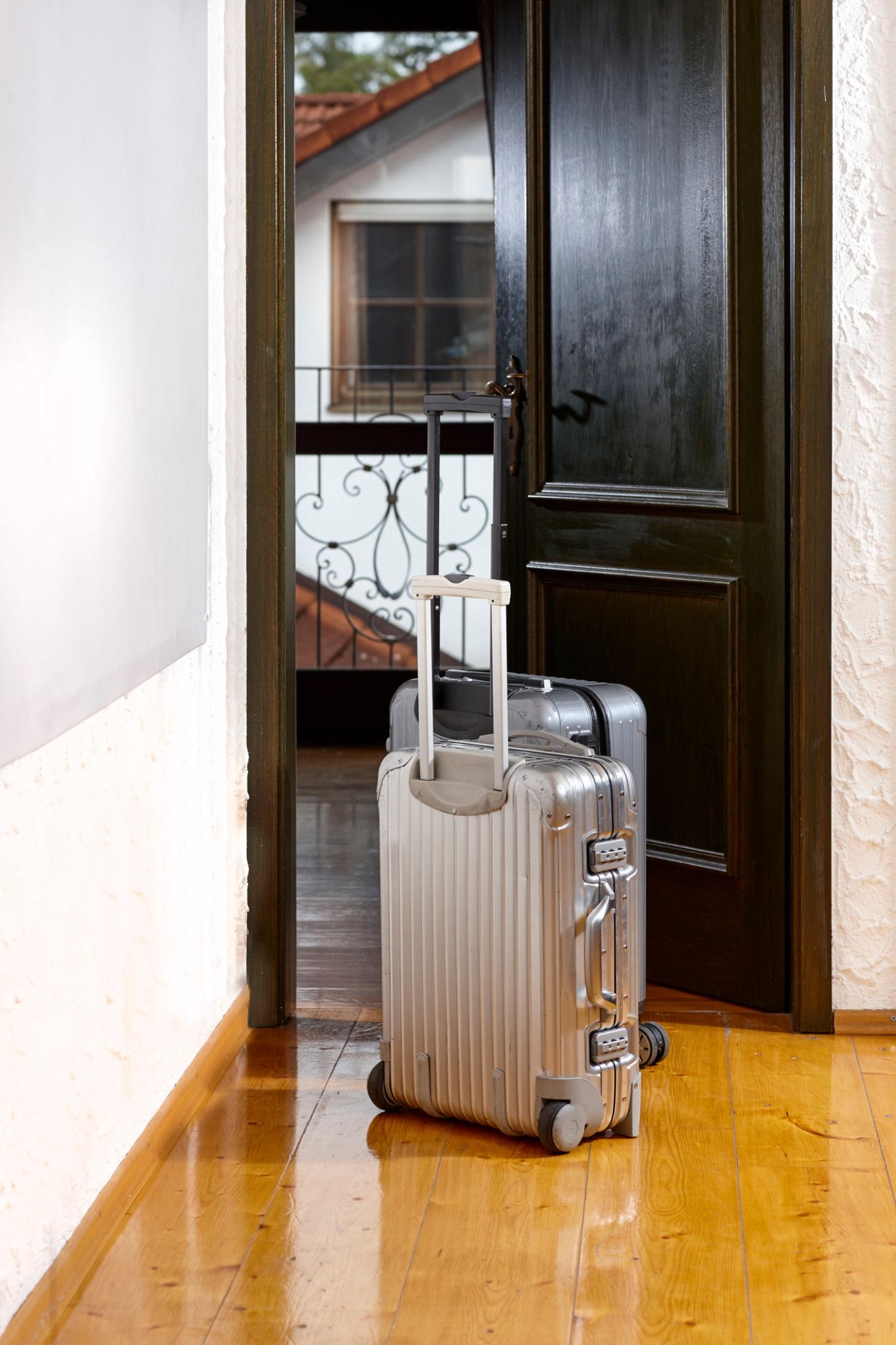 Packed travel bags ready by the door for a trip away from home